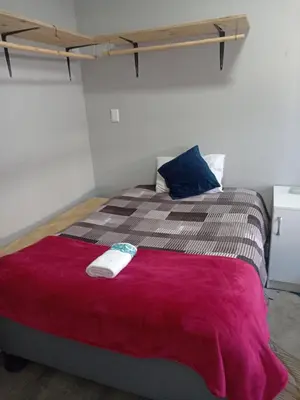 a bedroom with a large bed with a red blanket at Exotica Central guest house in Cape Town