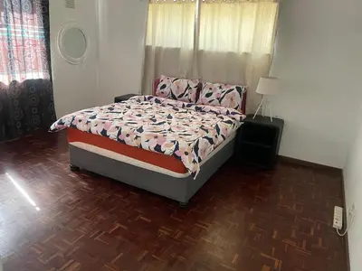 a bedroom with a bed and a wooden floor at House on Gill 2 in Cape Town