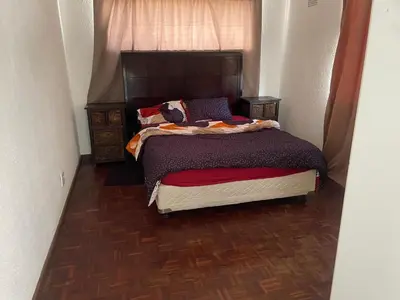 a bedroom with a bed with a wooden floor at House on Gill 2 in Cape Town