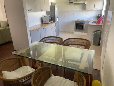 a kitchen with a glass table and some chairs at House on Gill 2 in Cape Town