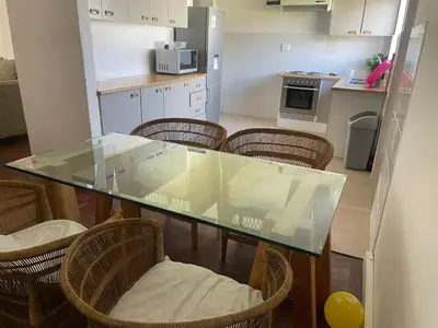a kitchen with a glass table and some chairs at House on Gill 2 in Cape Town