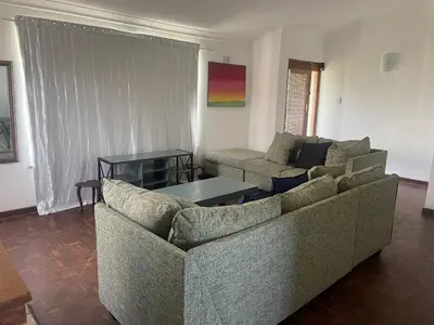 a living room with two couches and a table at House on Gill 2 in Cape Town