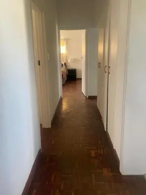 a hallway with a long hallway with a floor of wood at House On Gill 3 in Cape Town