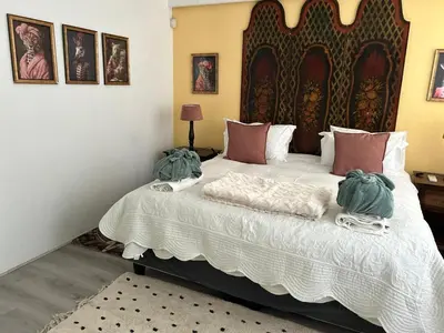 a bedroom with a large bed with two pillows at Franschhoek Wine Tram Apartment in Franschhoek