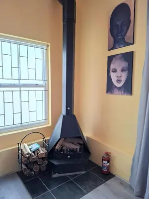 a black stove in a room with a window at Franschhoek Wine Tram Apartment in Franschhoek