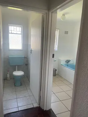 a bathroom with a blue toilet and a tub at House on Gill 25 in Cape Town