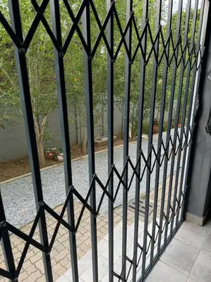 a black iron gate with a view of a courtyard at Slaap Self Catering in Paarl