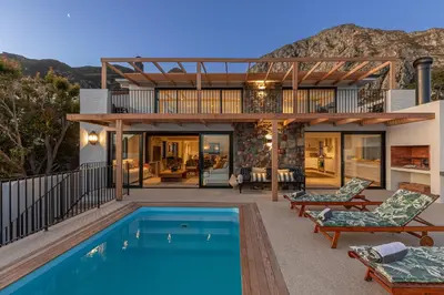 a home with a swimming pool and a house at Les Baleines Hermanus Villa in Hermanus