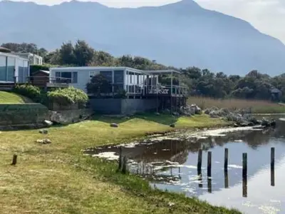 a house on the shore of a body of water at Moonshine in Hermanus