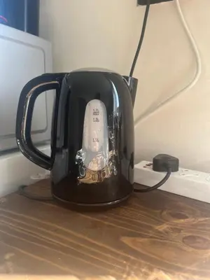 a black tea kettle sitting on top of a table at Relaxa Sleep & Go - Self Catering Accommodation in Cape Town