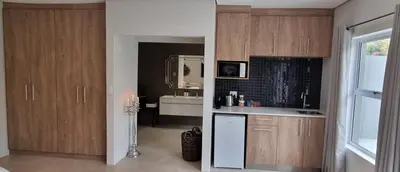 a kitchen with wooden cabinets and a white refrigerator at C'est la Vie 2 in Franschhoek