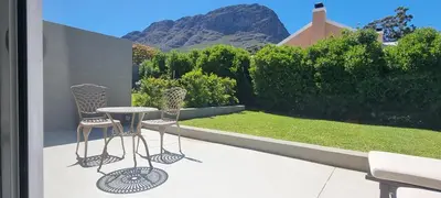 a patio with two chairs and a table on a balcony at C'est la Vie 2 in Franschhoek