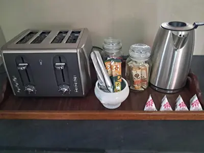 a counter with a toaster and a container of utensils at Ina se Huisie in Blouberg self Catering Apartment in Cape Town