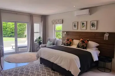 a bedroom with a large bed and a large window at C'est la Vie 4 in Franschhoek