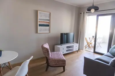 a living room with a tv and a table and chairs at Cape Mae Apartment Hotel in Cape Town