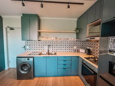 a kitchen with blue cabinets and a washing machine at Cape Mae Apartment Hotel in Cape Town