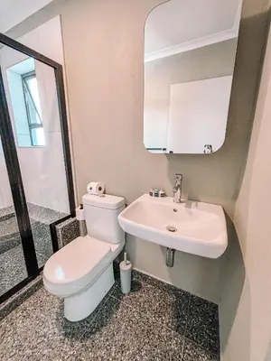 a bathroom with a white toilet and a sink at Cape Mae Apartment Hotel in Cape Town