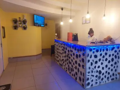 a woman sitting at a counter in a restaurant at KK Guesthouse in Cape Town