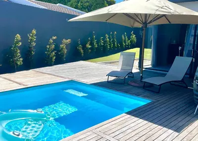 a swimming pool with two chairs and an umbrella at The View in Cape Town