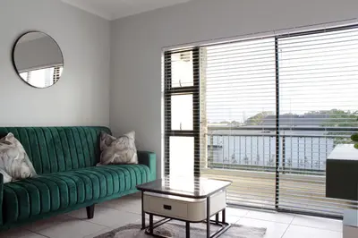 a living room with a green couch and a large window at The Jade Escape in Cape Town