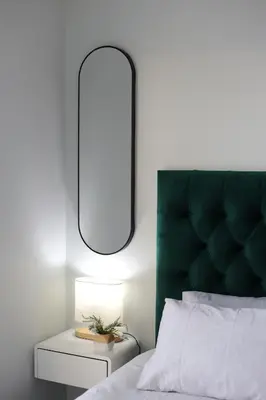 a bedroom with a green headboard and a table with a lamp at The Jade Escape in Cape Town