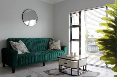 a green couch in a living room with a table at The Jade Escape in Cape Town