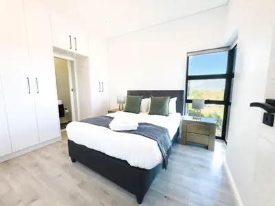 a bedroom with a large bed and a window at Greystone Executive Apartments in Cape Town