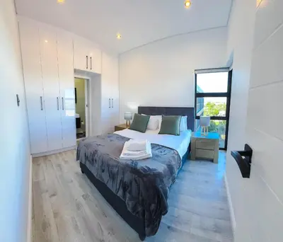 a bedroom with a king sized bed and a window at Greystone Executive Apartments in Cape Town