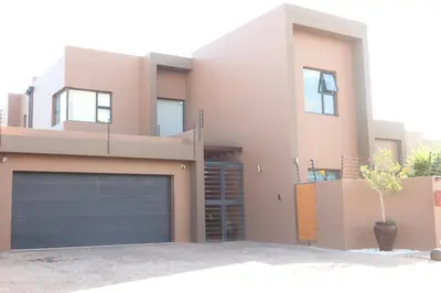 a house with a garage door in front of it at Trinity in Cape Town