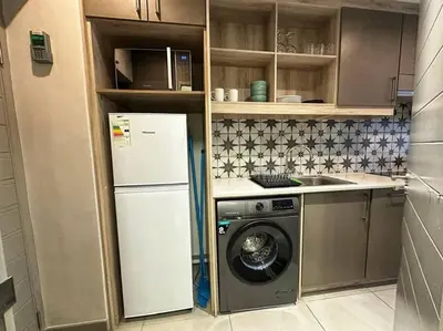 a kitchen with a refrigerator and a washing machine at The Den at 41- Parking included in Stellenbosch