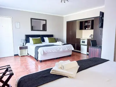 a hotel room with two beds and a kitchen at Ilanga Du Cap Hotel in Cape Town