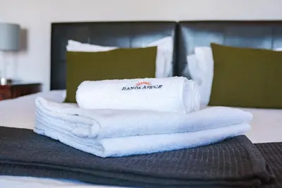 a pile of towels sitting on top of a bed at Ilanga Du Cap Hotel in Cape Town