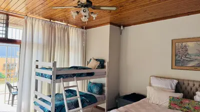 a bedroom with bunk beds and a ceiling fan at Leisure Lodges Family Room Parow in Cape Town