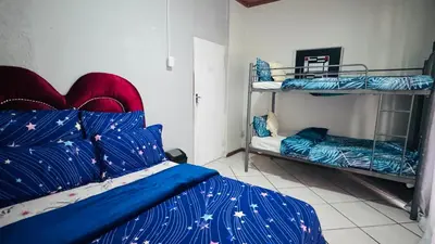 a bedroom with two bunk beds with blue comforters at Leisure Lodges Family Room Parow in Cape Town