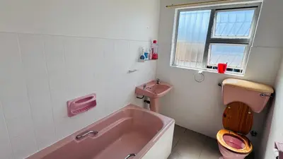 a bathroom with a pink tub and a sink at Leisure Lodges Family Room Parow in Cape Town