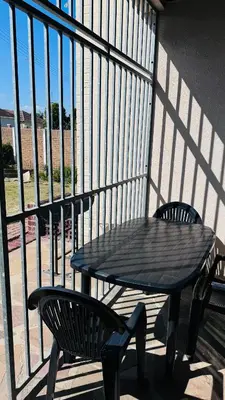 a black table and two chairs on a balcony at Leisure Lodges Family Room Parow in Cape Town