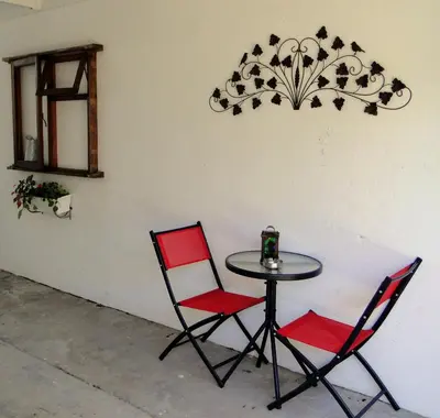 a table with two chairs and a table with a candle on it at Our Nest Guest House in Kleinmond