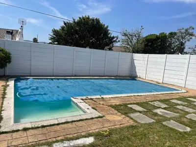 a swimming pool in front of a white fence at Mary's Cape in Cape Town