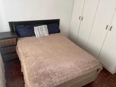 a small bed in a room with white cabinets at Mary's Cape in Cape Town