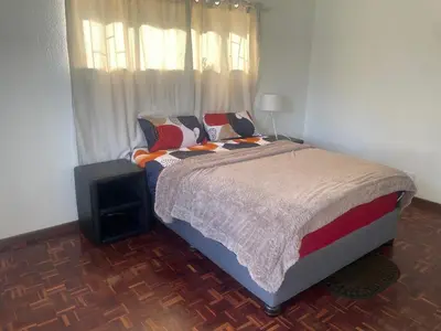 a bedroom with a bed and a television in it at Mary's Cape in Cape Town