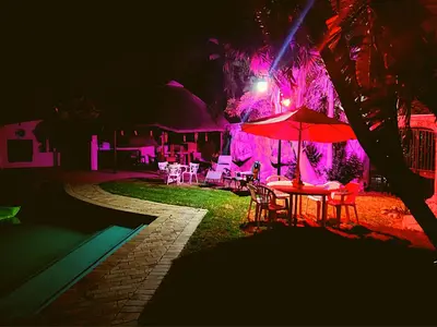 a patio with a table and an umbrella at night at Budget Haven Durbanville in Cape Town