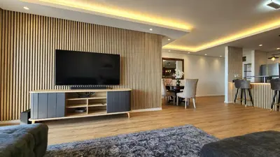 a living room with a flat screen tv on a wall at Capri 504, Island Club, Century City in Cape Town