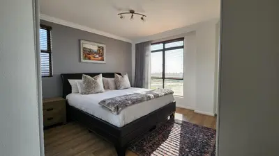 a bedroom with a bed and a window at Capri 504, Island Club, Century City in Cape Town