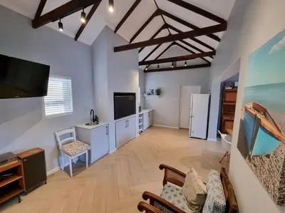 a large living room with a flat screen tv at Spacious Lanes Cottage and Garage Parking in Cape Town