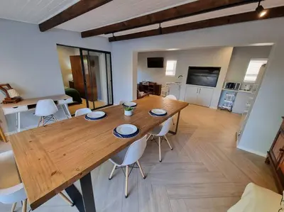 a wooden table and chairs in a living room at Spacious Lanes Cottage and Garage Parking in Cape Town
