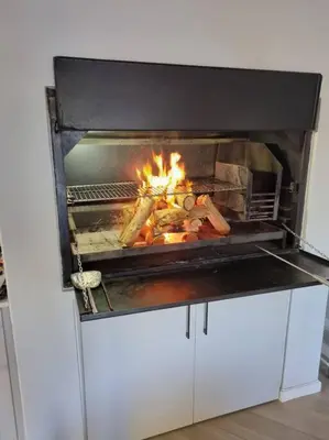 a fire is burning in a stove in a kitchen at Spacious Lanes Cottage and Garage Parking in Cape Town