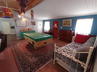 a living room with a pool table and a bed at Sunset Splendour in Pringle Bay