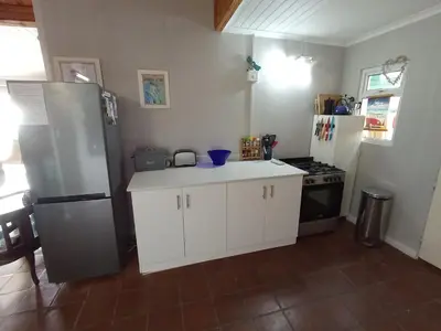 a kitchen with white cabinets and a refrigerator at Sunset Splendour in Pringle Bay