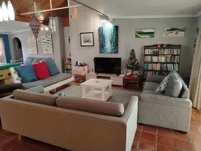 a living room with two couches and a television at Sunset Splendour in Pringle Bay