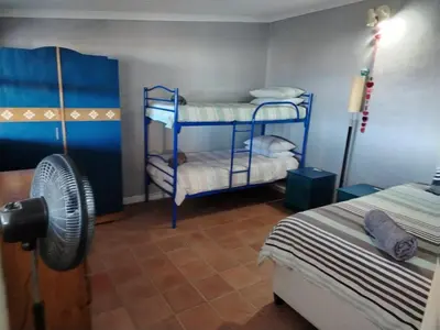 a bedroom with two bunk beds and a fan at Sunset Splendour in Pringle Bay